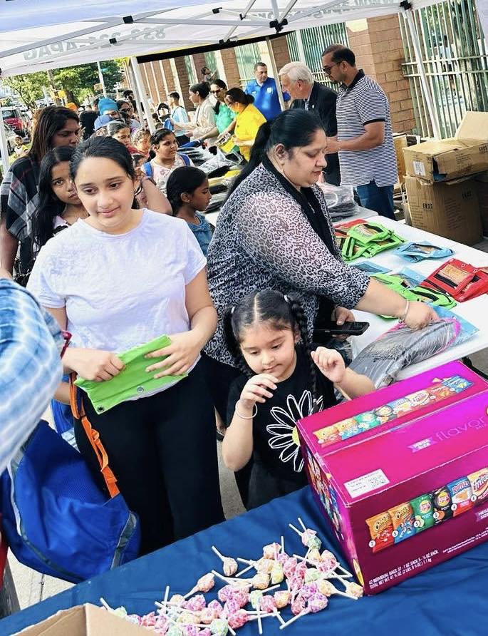 Families receiving school supplies at an APAG Cares back-to-school event