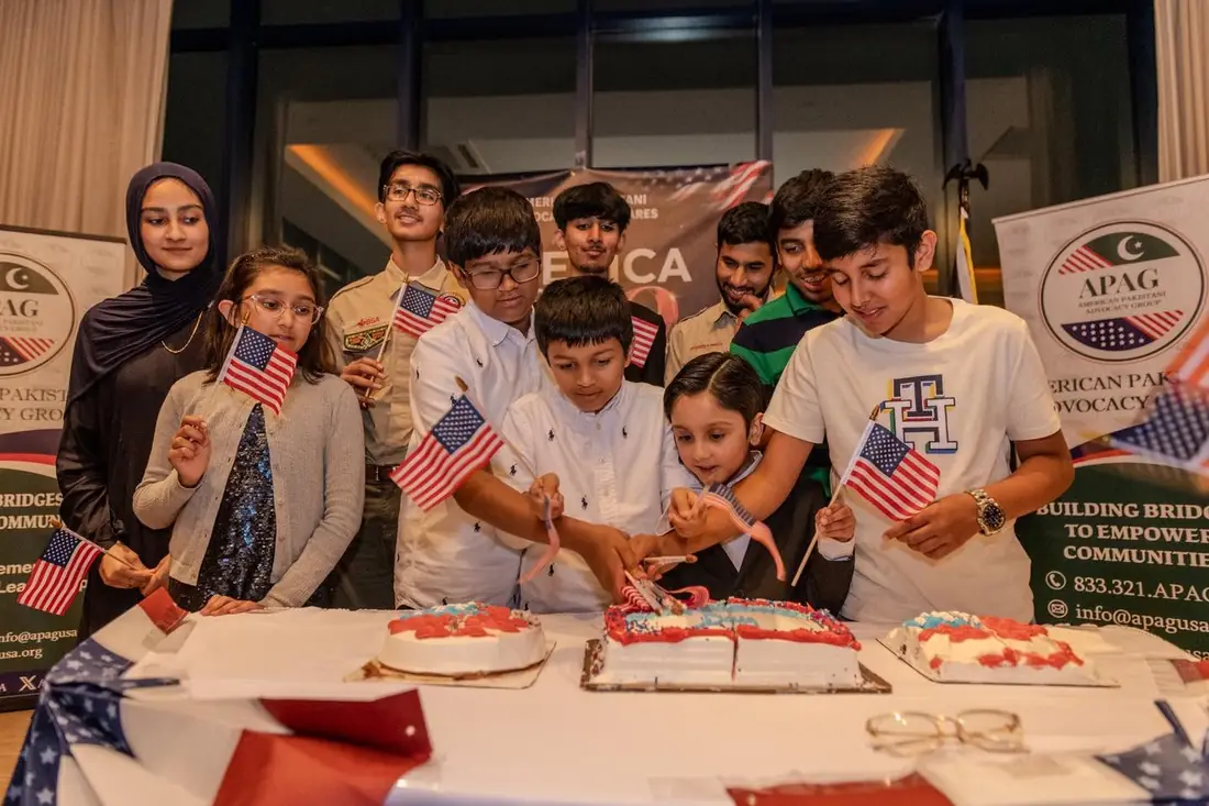 Youth and community members gathered around cakes and American flags during America at 250