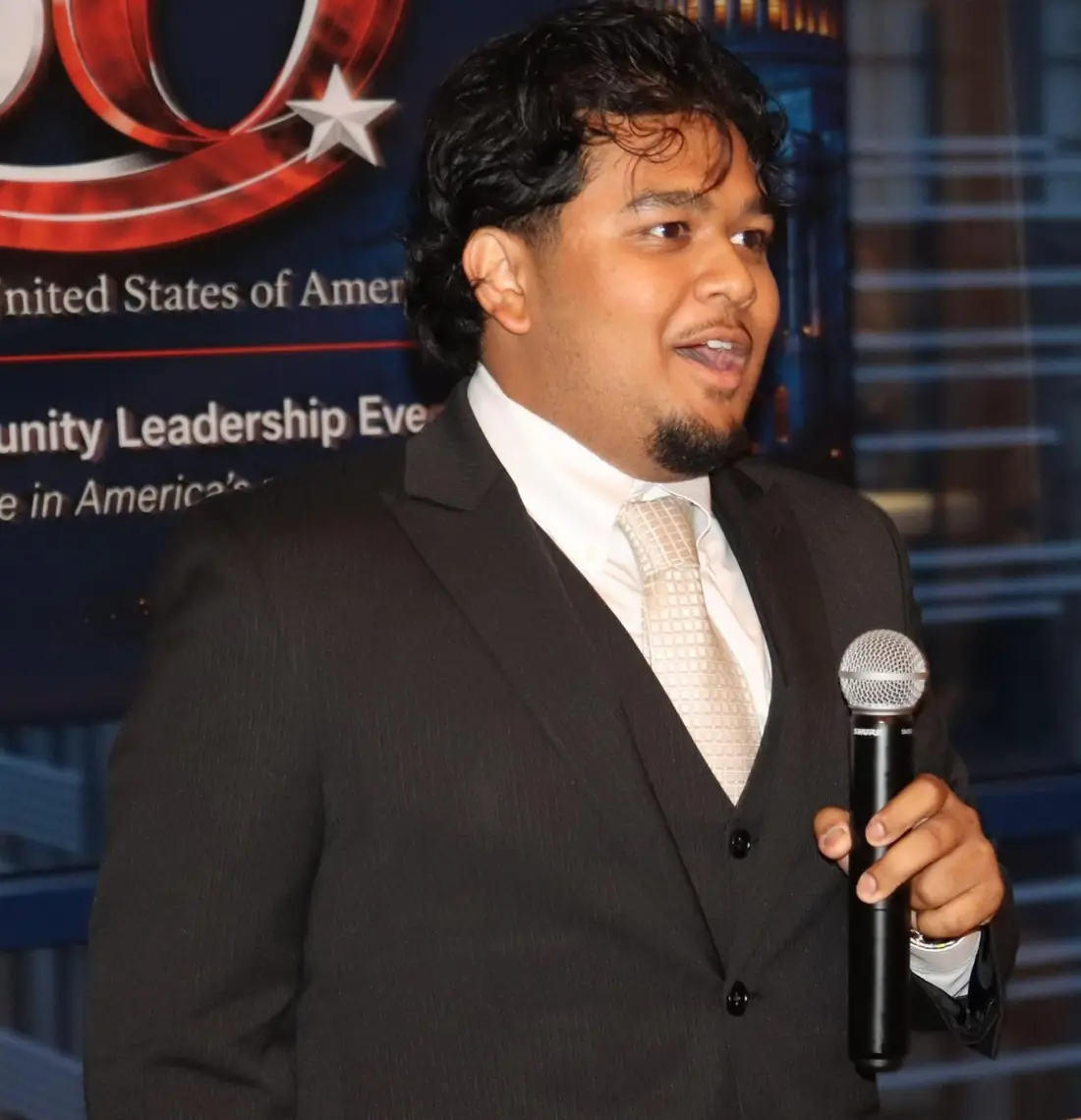 Community speaker holding a microphone during America at 250