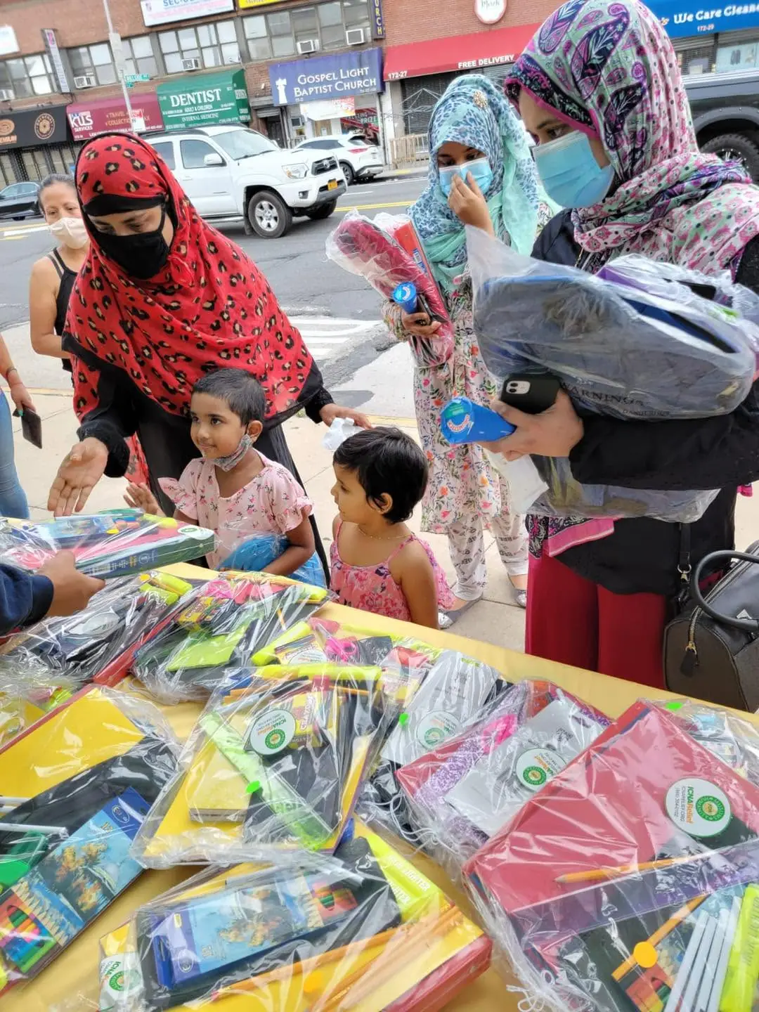 Families and children receiving school supplies during an APAG Cares back-to-school drive