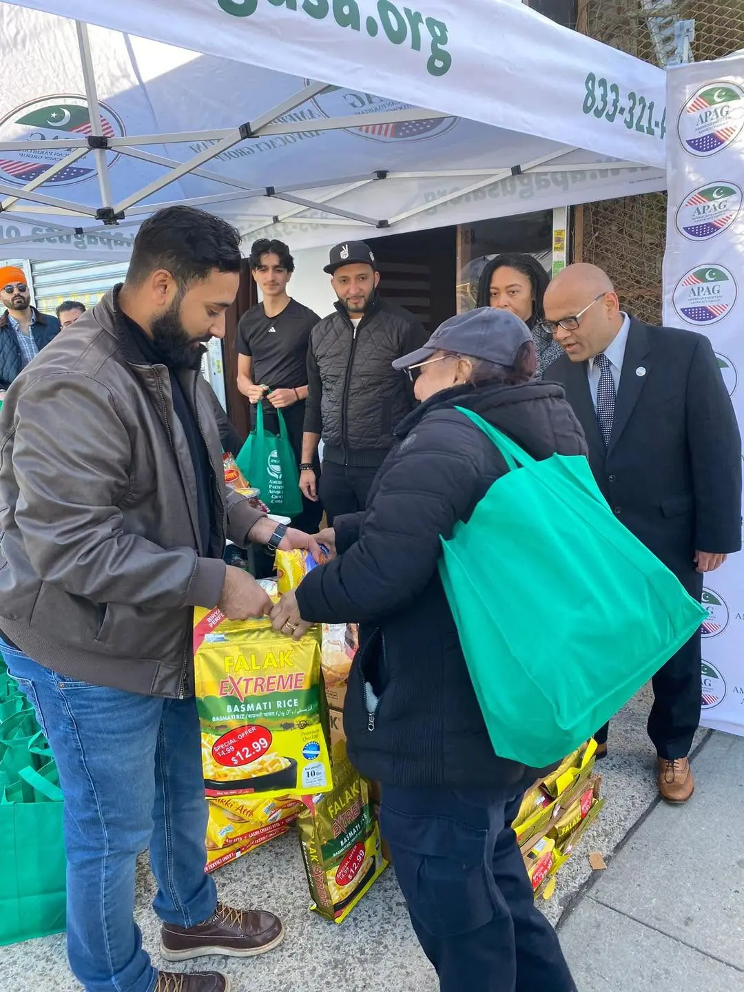 APAG Cares volunteer handing a food bag to a community member