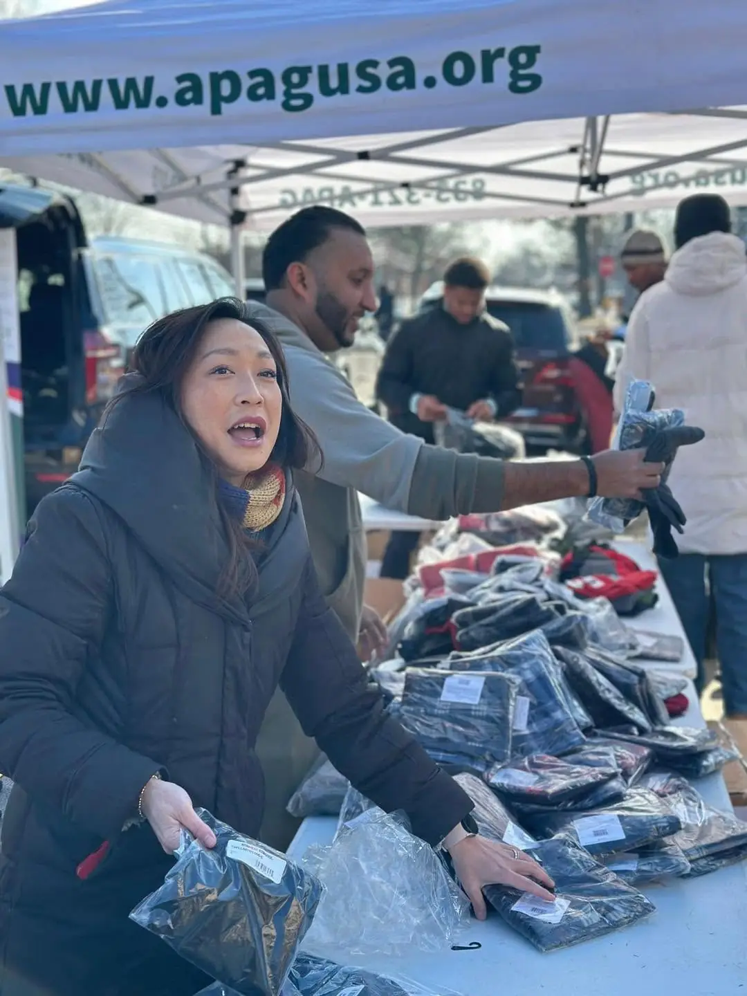 Tables of packaged winter clothing at an APAG Cares drive